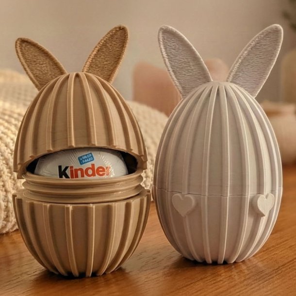 3D printede p�ske�g med kanin�rer p� tr�bord, det ene �bent med plads til chokolade